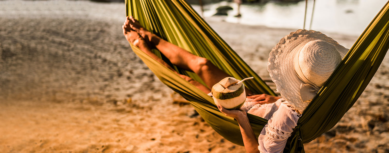 eine Frau liegt in einer Hängematte am Strand